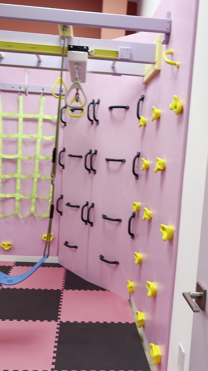 Pink climbing wall and climbing net in our sensory gym