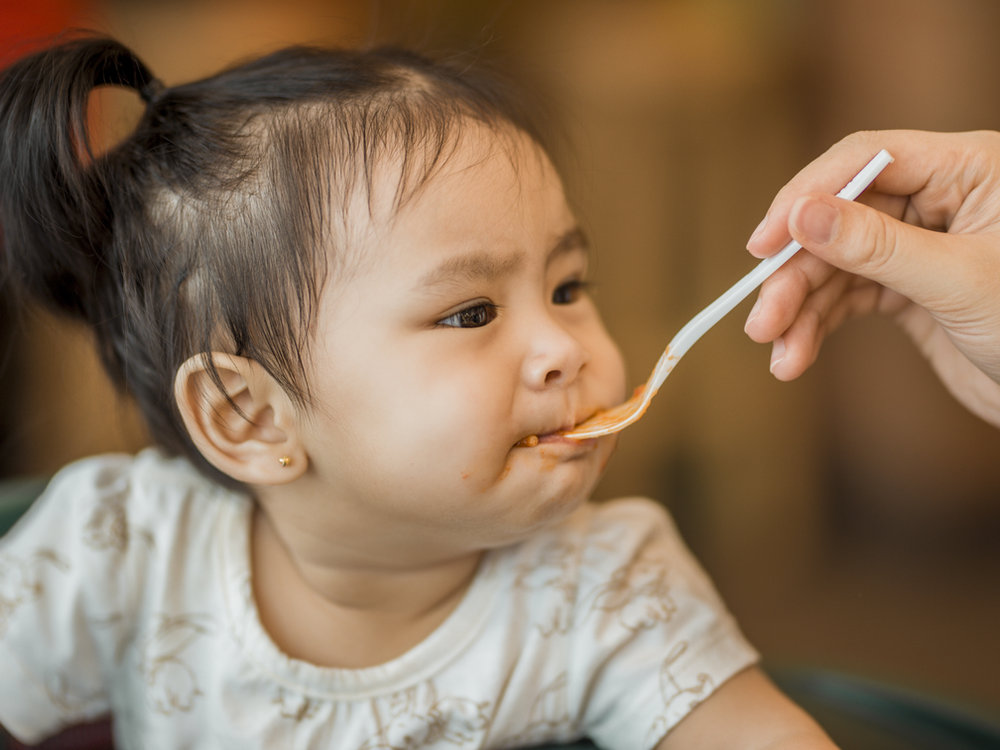 A caregiver supporting a child at mealtime